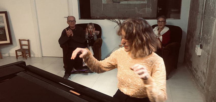 Hada at home playing piano with an audience